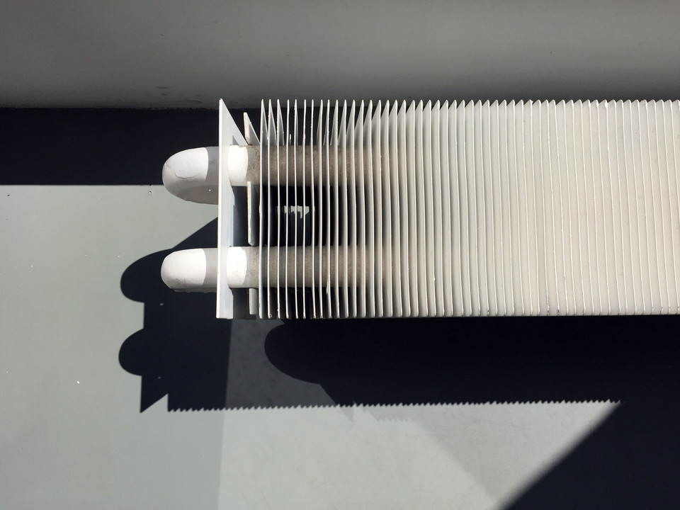 A radiator casting a shadow on a wall